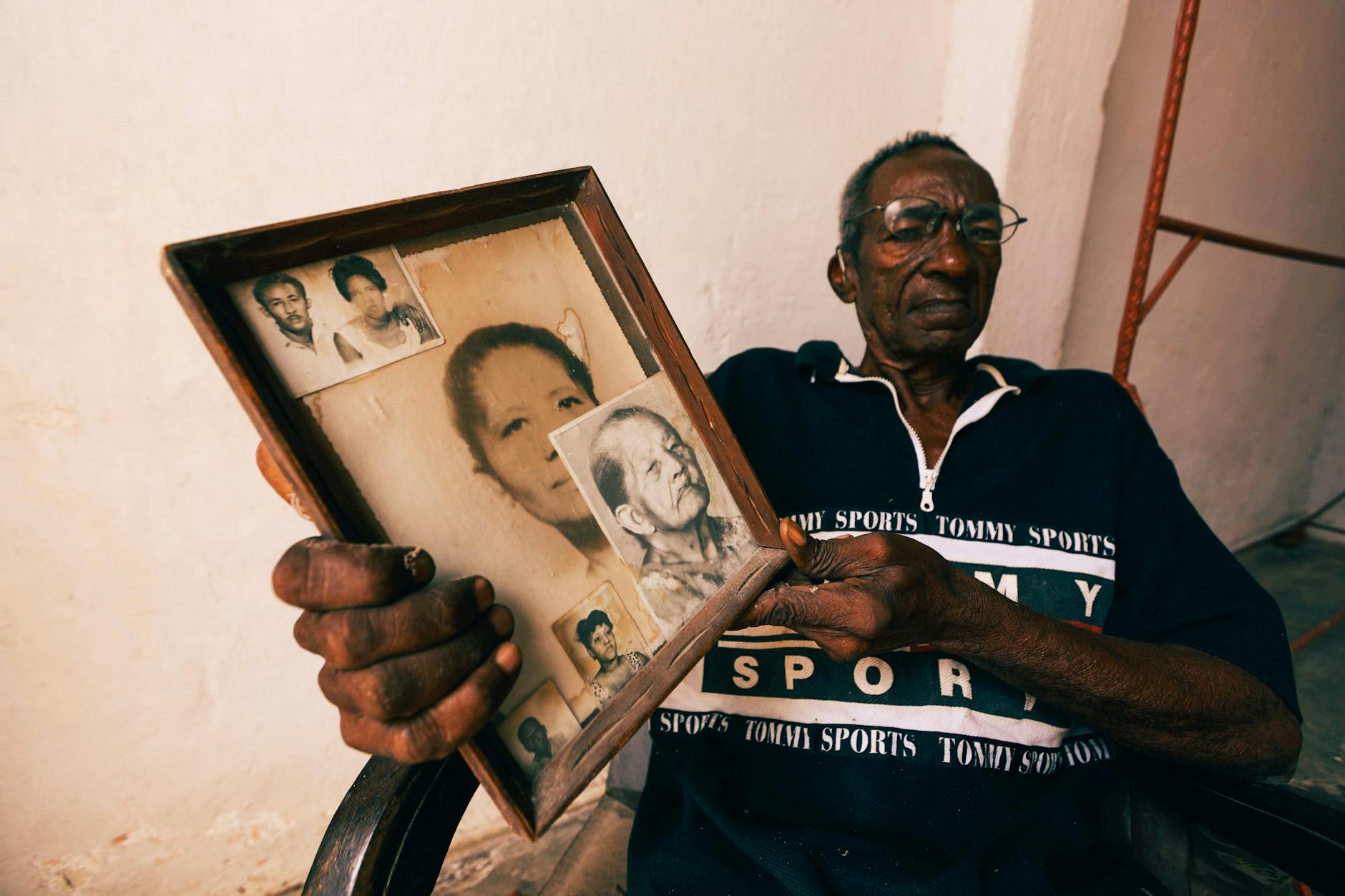 Homme noir qui présente un cadre avec des photos de famille anciennes Photo de Mehmet Turgut  Kirkgoz sur Pexels.com